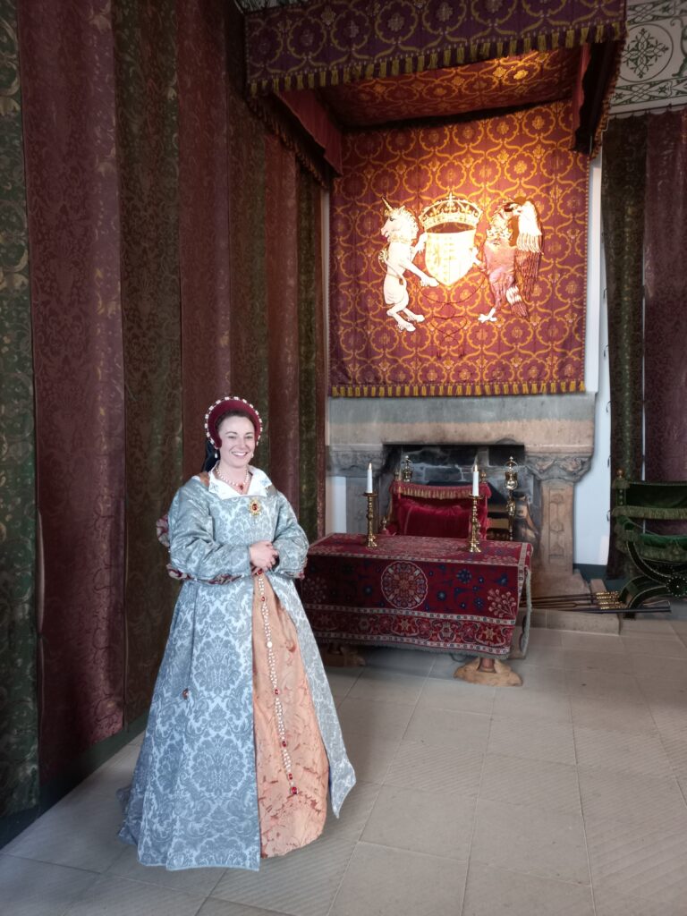 Dame in historisch kostuum in de gerestaureerde slaapkamer van het paleis in Stirling Castle.