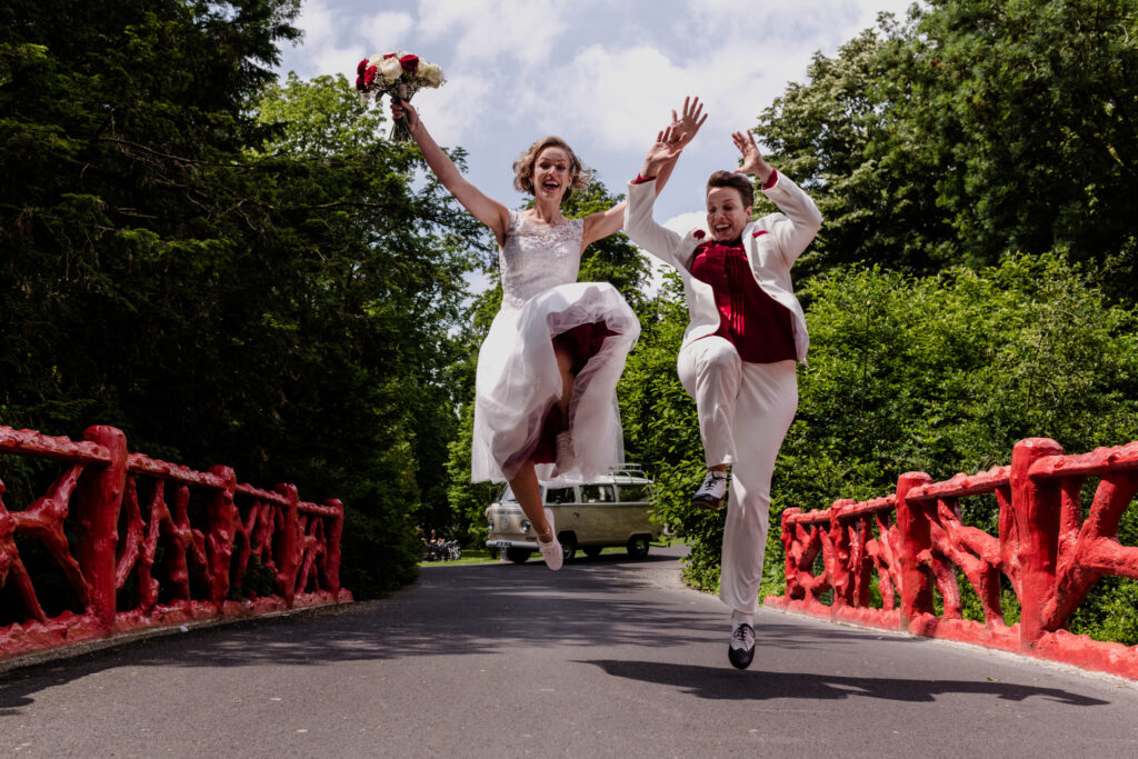 Twee bruiden springen in de lucht op een brug